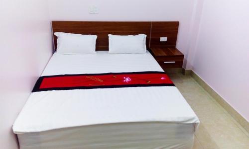 a bed in a small room with a red blanket on it at Ruby Hostel Hà Giang in Ha Giang