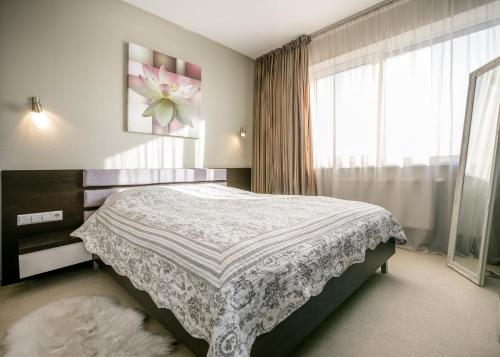 a bedroom with a bed and a large window at Amber View 14th Floor in Klaipėda