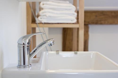 a bathroom sink with a faucet and some towels at De Toffe Peer Recreatie in Ruinerwold