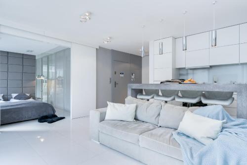 a white living room with a couch and a bed at Elite Apartments Prestige Old Town in Gdańsk