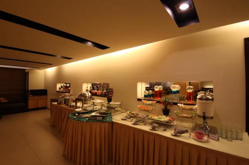 a restaurant with a counter with food on it at Minerva Grand Secunderabad in Hyderabad