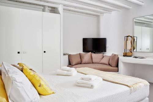 un soggiorno bianco con divano e letto di Villa Etcetera a Elia Beach