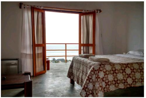 a bedroom with a bed and a large window at Altavista Casa de Huespedes in Vichayito