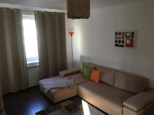 a living room with a couch and a window at Central Home in Piatra Neamţ