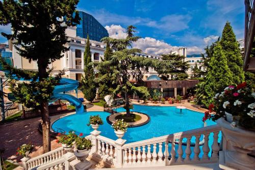 een balkon met uitzicht op een zwembad en een glijbaan bij Oreanda Premier Hotel in Jalta