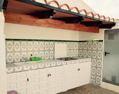 kuchnia z białymi szafkami i płytkami na ścianie w obiekcie Clubrent - Townhouse La Merced w mieście Calpe