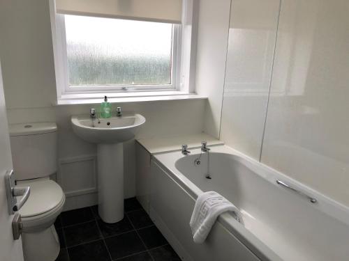 La salle de bains est pourvue d'une baignoire, d'un lavabo et de toilettes. dans l'établissement Glenrothes Central Apartments - One bedroom Apartment, à Glenrothes