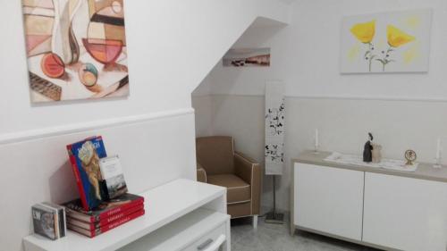 een witte woonkamer met een stoel en een tafel bij Casa vacanza "U cardinali" in Pachino