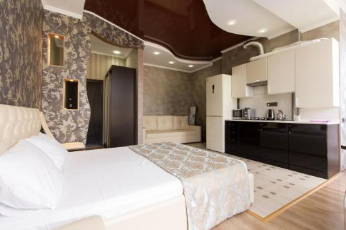 アドレルにあるStudio in Monaco Clubのベッドルーム(大きな白いベッド1台付)、キッチンが備わります。