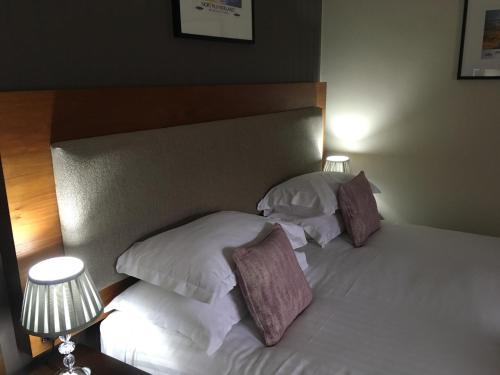 a bedroom with two beds with white pillows at The Seaton Lane Inn - The Inn Collection Group in Seaham