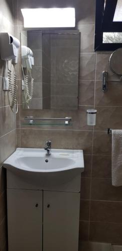 a bathroom with a white sink and a mirror at Hotel la Coccinelle in Bamako