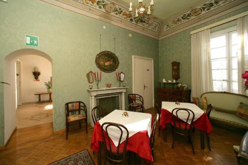 a dining room with two tables and a fireplace at Hotel Sereno in Cogoleto