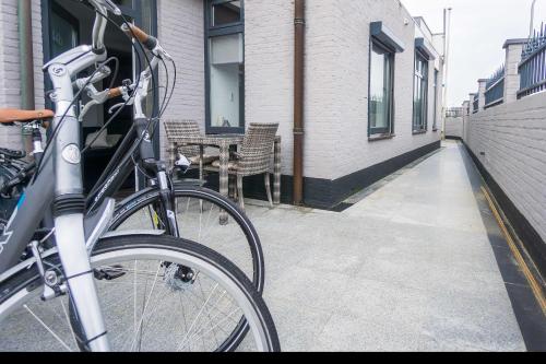 a bike parked on a sidewalk next to a building at Strandzand in Noordwijk aan Zee