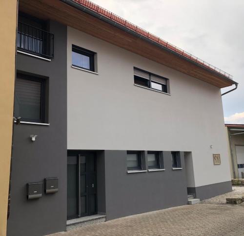 a white and gray house with black windows at Krug-Apartments in Ebelsbach