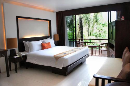 パトンビーチにあるSafari Beach Hotel - SHA Extra Plusのベッドルーム(大型ベッド1台、バルコニー付)