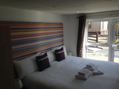 a bedroom with a large bed with towels on it at Waves Guest Suites in Castel