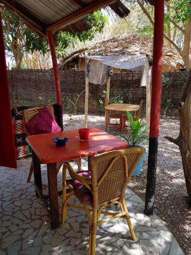 a wooden table and chairs under an umbrella at Evergreen Eco Lodge Retreat in Tujering