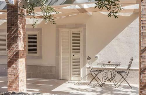 a patio with a table and chairs in front of a house at B&B Antico Ulivo in Monopoli