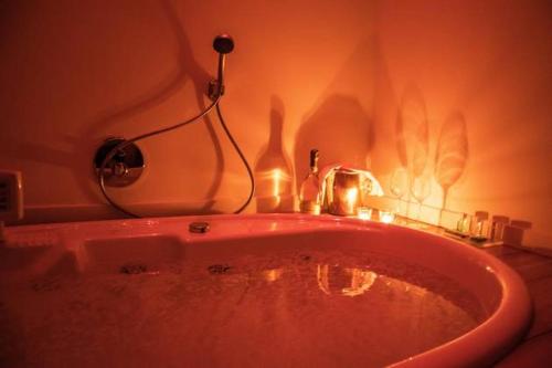 a red bath tub in a bathroom with a lighted at Joia Hotel & Luxury Apartments RTA in Brusaporto