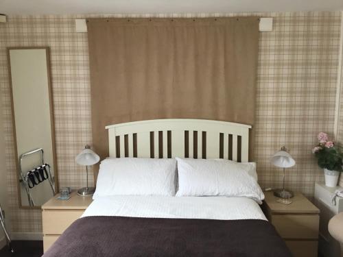 a bedroom with a large bed and two lamps at Ingleneuk Bed and Breakfast in Edinburgh