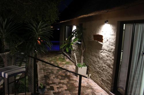 a balcony of a house at night with a plant at Woodpecker Lodge B&B in Hoedspruit
