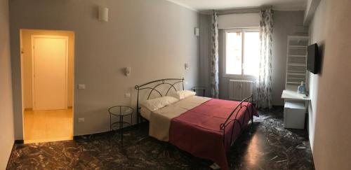 a bedroom with a bed with a red blanket and a window at Riva reno 54 rooms in Bologna