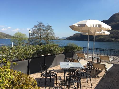 a patio with a table and chairs and an umbrella at Hotel Ristorante La Quartina in Mergozzo