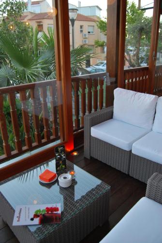 a porch with a couch and a table on a balcony at Destinos De Sol Los Alcazares - Montepío Minería in Los Alcázares