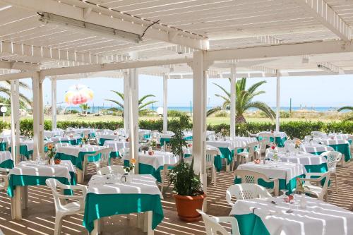 a set up for a wedding at the beach with white tables and chairs at El Mouradi Mahdia in Mahdia
