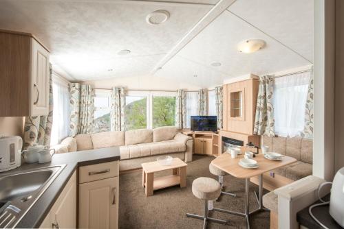 a kitchen and living room with a couch and a table at Sandaway Holiday Park in Combe Martin