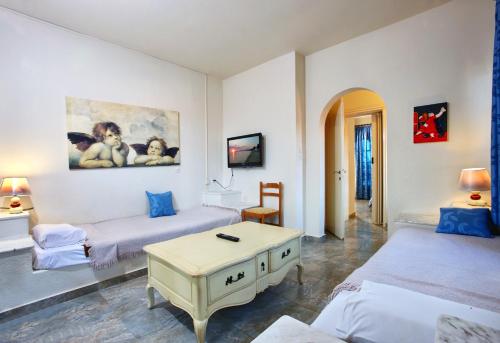 un soggiorno con 2 letti e un tavolo di Assa Maris Beach Hotel a Pyrgadikia
