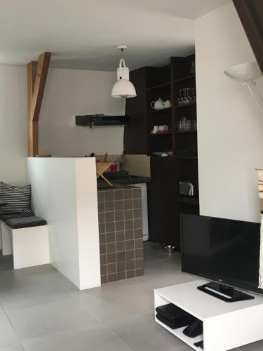 un salon avec une télévision sur une table blanche dans l'établissement L'étoile de Trouville, à Trouville-sur-Mer