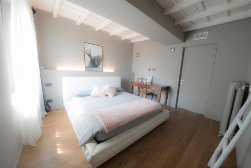 um quarto com uma cama branca e piso em madeira em My Lovely Place Navigli em Milão