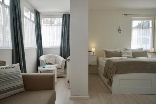オストゼーバート・ゼリンにあるFerienappartement-Moenchgut-07の白いベッドルーム(ベッド1台、椅子付)