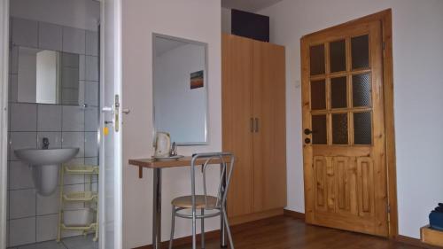 a bathroom with a sink and a chair next to a door at Dom Wczasowy Irys in Węgierska Górka