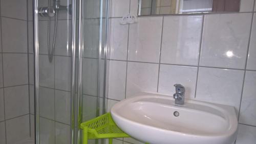 a white sink in a bathroom with a shower at Dom Wczasowy Irys in Węgierska Górka