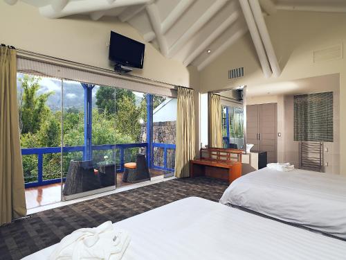 a bedroom with two beds and a large window at Aranwa Sacred Valley Hotel & Wellness in Urubamba