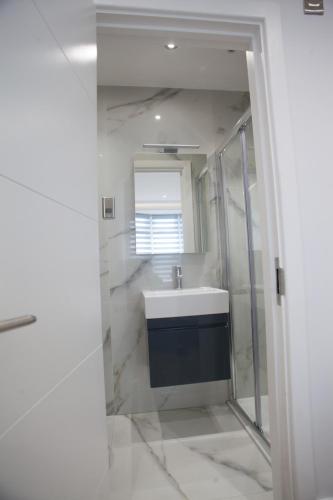 a bathroom with a sink and a mirror at Goldbeaters House in Edgware