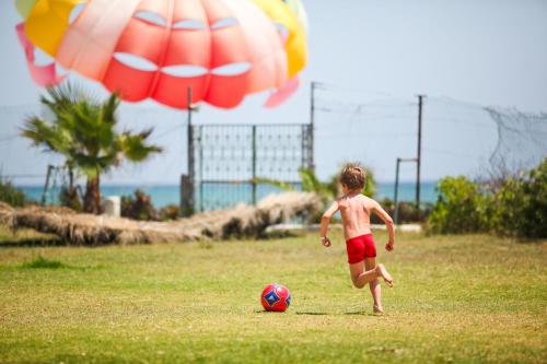 a young boy playing with a soccer ball in a field at El Mouradi Mahdia in Mahdia