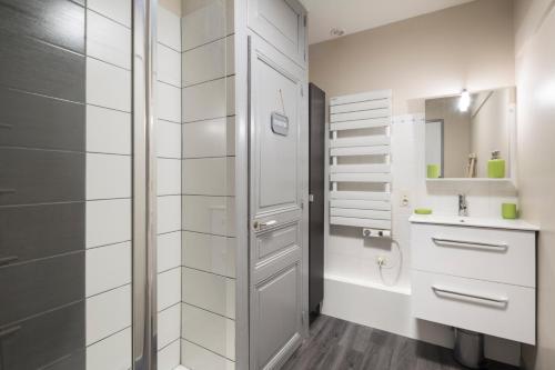 une salle de bain blanche avec une douche et un lavabo dans l'établissement L'Aviron by Cocoonr, à Saint-Malo