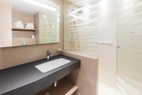 La salle de bains est pourvue d'un lavabo et d'un miroir. dans l'établissement Résidence Neptunia, à Saint-Malo