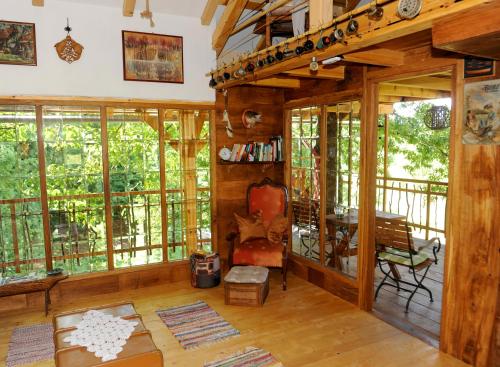 a living room with glass windows and a wooden floor at Treehouse Resnice -Mrežnica in Barilović