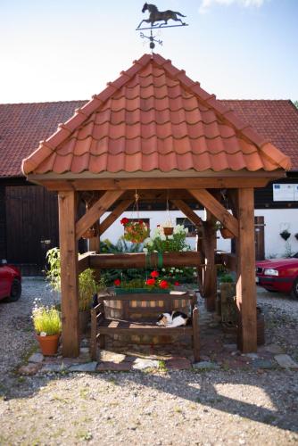 a wooden gazebo with a red roof at Siedlisko Sabinowo in Węgorzewo