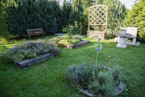 a garden with a bench and some plants in the grass at Siedlisko Sabinowo in Węgorzewo