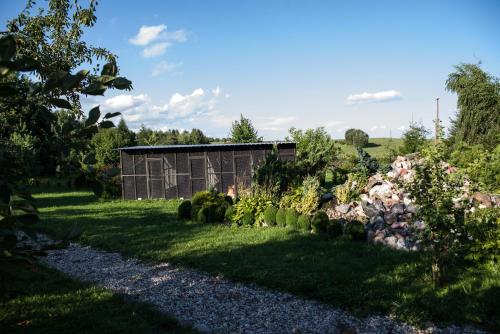 a garden with rocks and a building in the background at Siedlisko Sabinowo in Węgorzewo