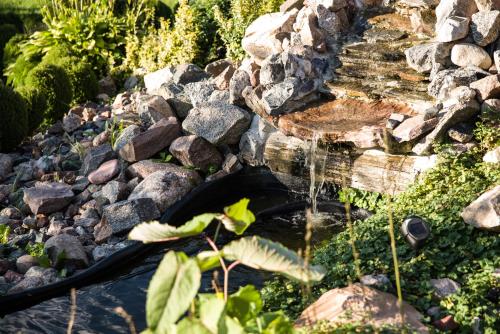 a water fountain in a garden with rocks at Siedlisko Sabinowo in Węgorzewo