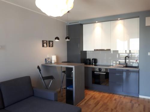 a kitchen with a couch and a table in a room at Nova Apartament in Białystok