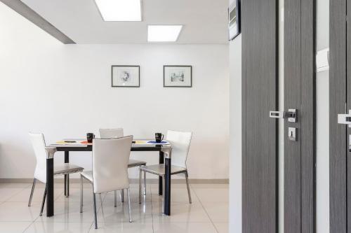 a dining room with a table and white chairs at Wroclaw Inn Apartments in Wrocław