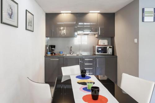 a kitchen with a table with chairs and a microwave at Wroclaw Inn Apartments in Wrocław