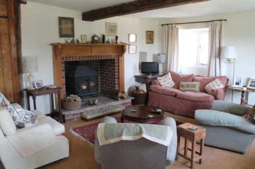 a living room with a couch and a fireplace at Grove Farm B&B in Newnham